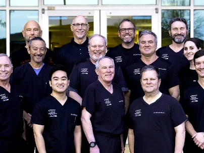 The Little Rock Family Dental Care doctors and clinical team in their black practice scrubs.
