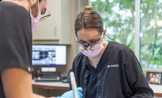 Dr. Rachel Mann, wearing loupes, preparing to treat a patient.