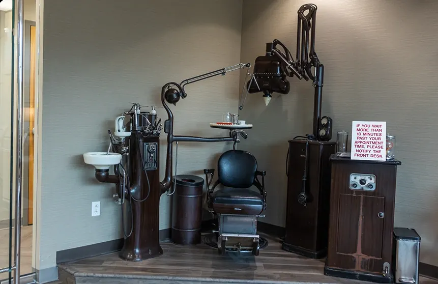 An antique dental chair and cabinet on display in the office.